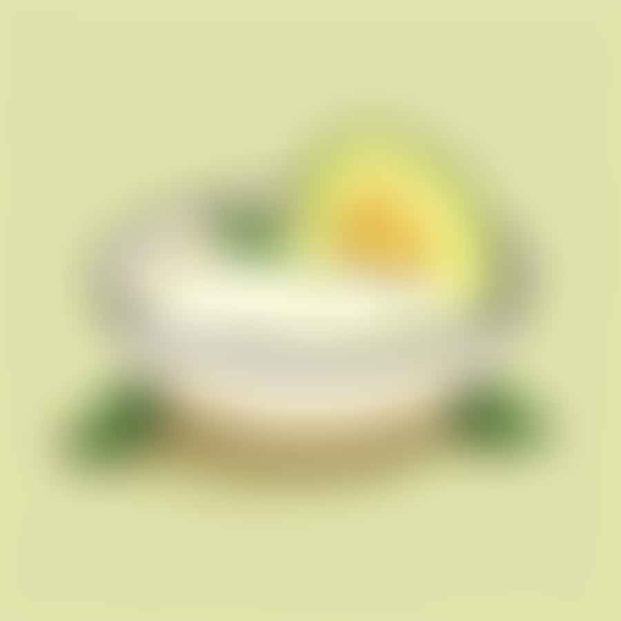 A creamy mixture of avocado, coconut oil, and lemon juice in a bowl.